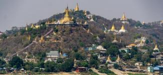 Myanmar temple on top of a hill with pointed gold roofs