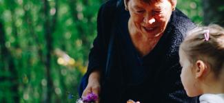 Image of woman showing flowers to a child