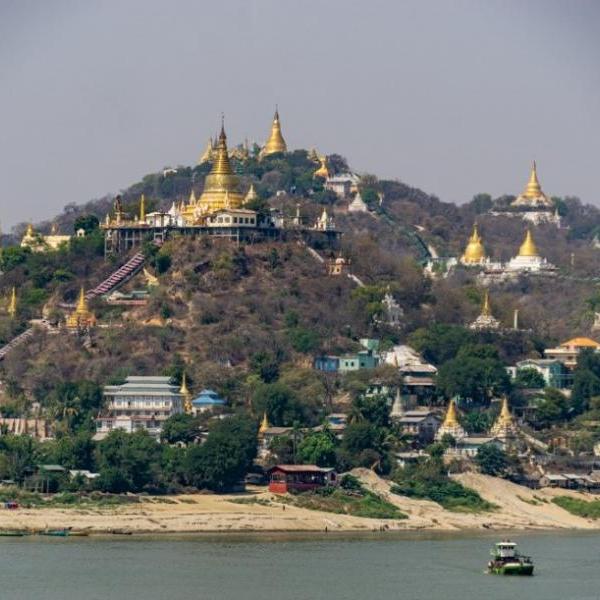 Myanmar temple on top of a hill with pointed gold roofs